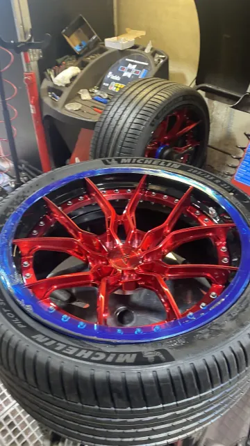 Red and blue wheels fitted with Michelin tyres inside the workshop.